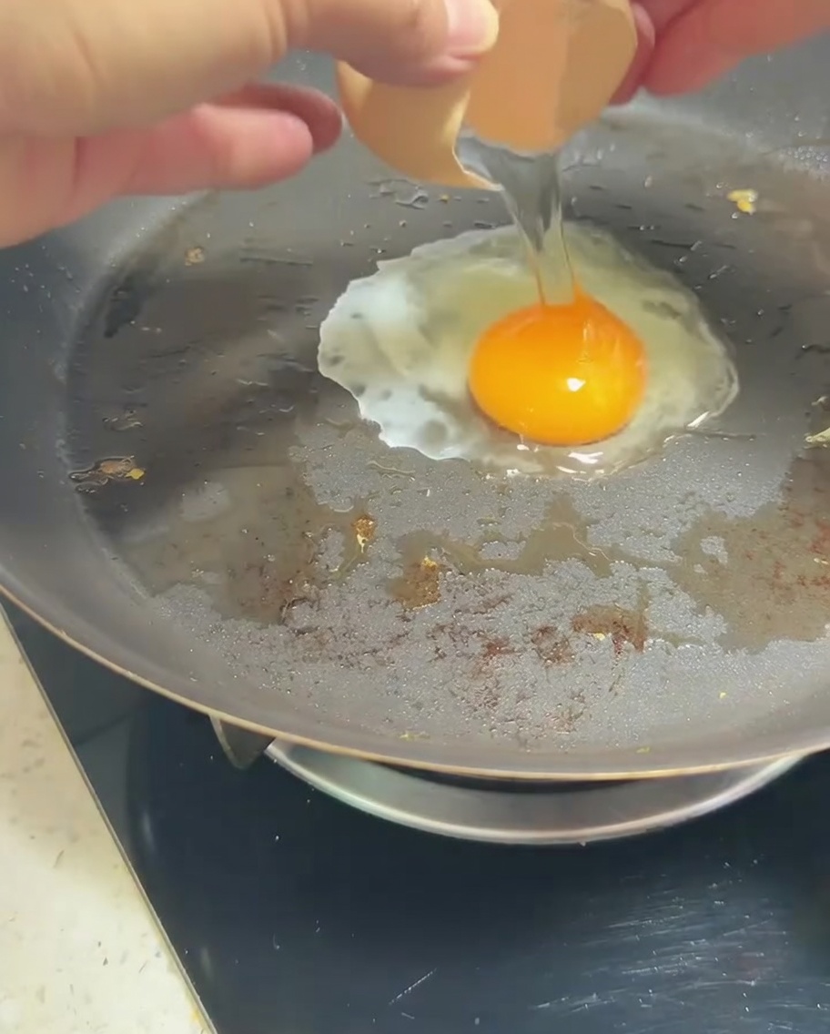 Un œuf au plat dans la poêle avec un jaune brillant.