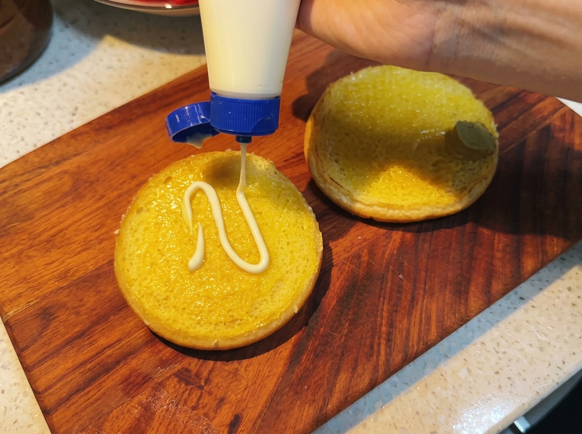 Mayonnaise ajoutée sur la couche de moutarde.