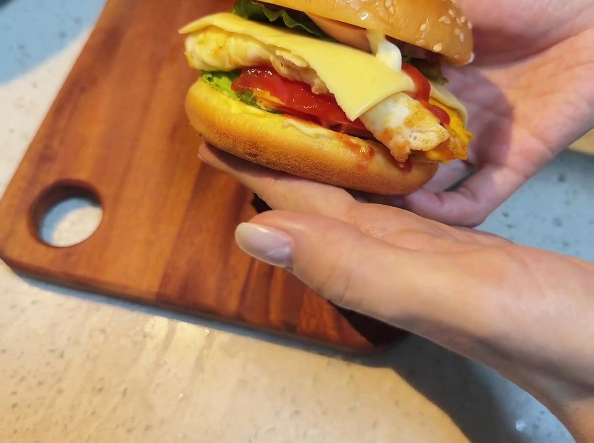 Tranche de fromage posée sur le burger chaud.