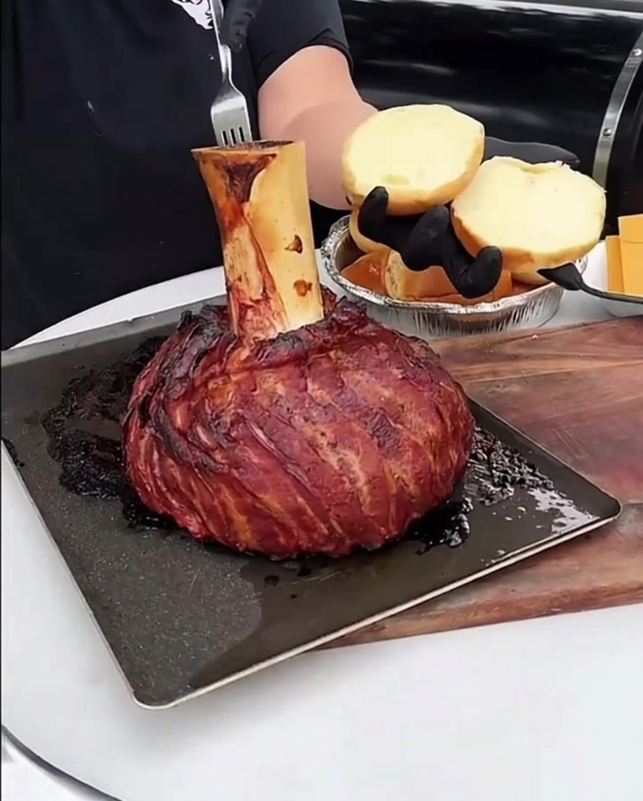 Une cuillerée de moelle rôtie étalée sur un pain à burger toasté doré.