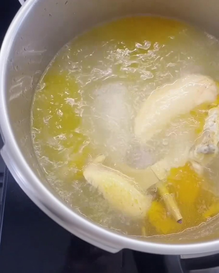 Nouilles sèches immergées dans une casserole de bouillon de poulet bouillant.