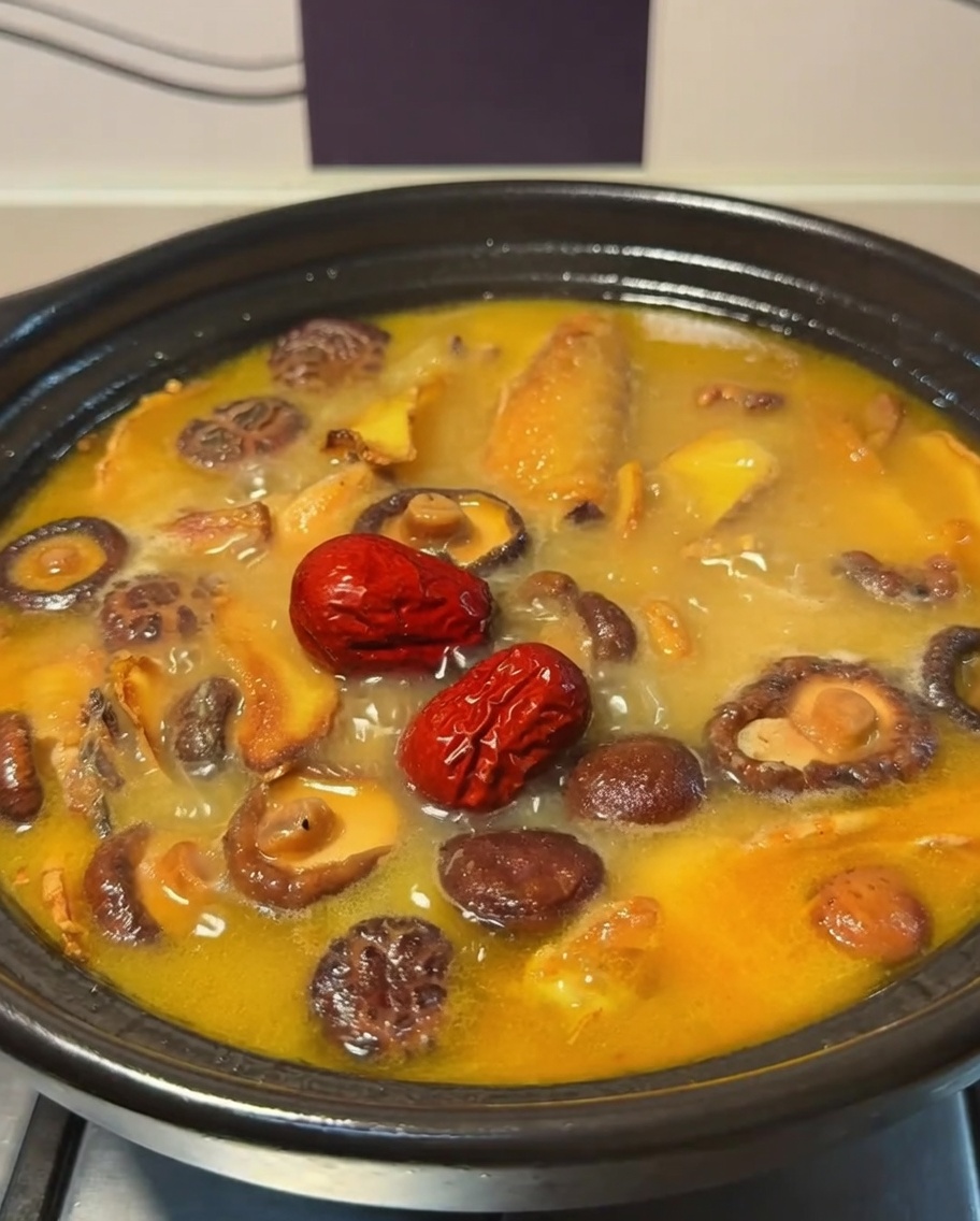 Dattes rouges flottant dans le bouillon de poulet et de champignons frémissant.