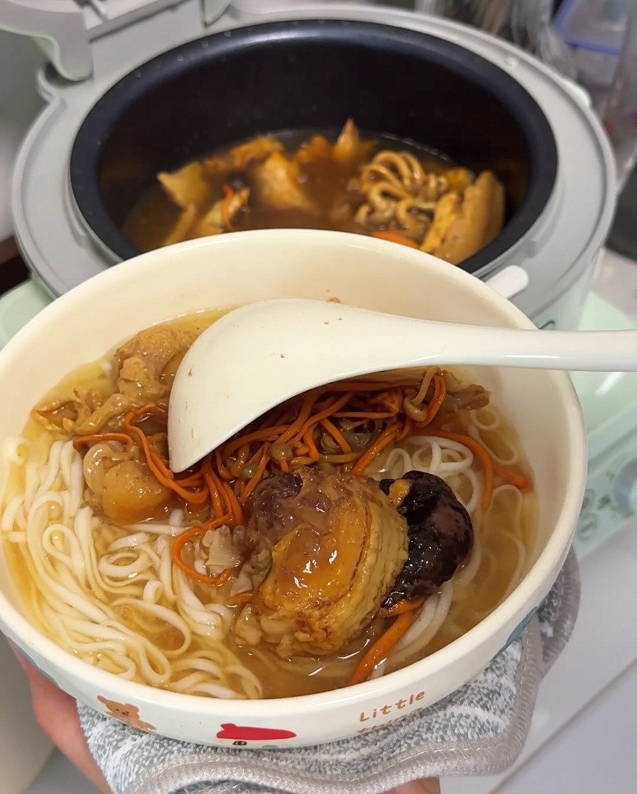 Un bol de nouilles blanches prêtes à être servies avec le bouillon de poulet.