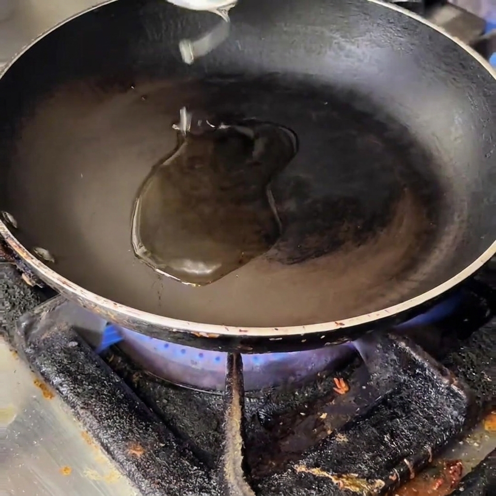 Oignon, ail, bacon, champignons et asperges en train de revenir dans une poêle chaude huilée.