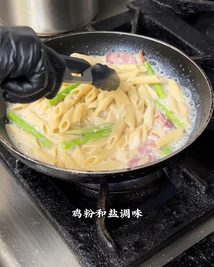 Pennes remuées avec la sauce blanche et la truffe noire dans une poêle à feu moyen.