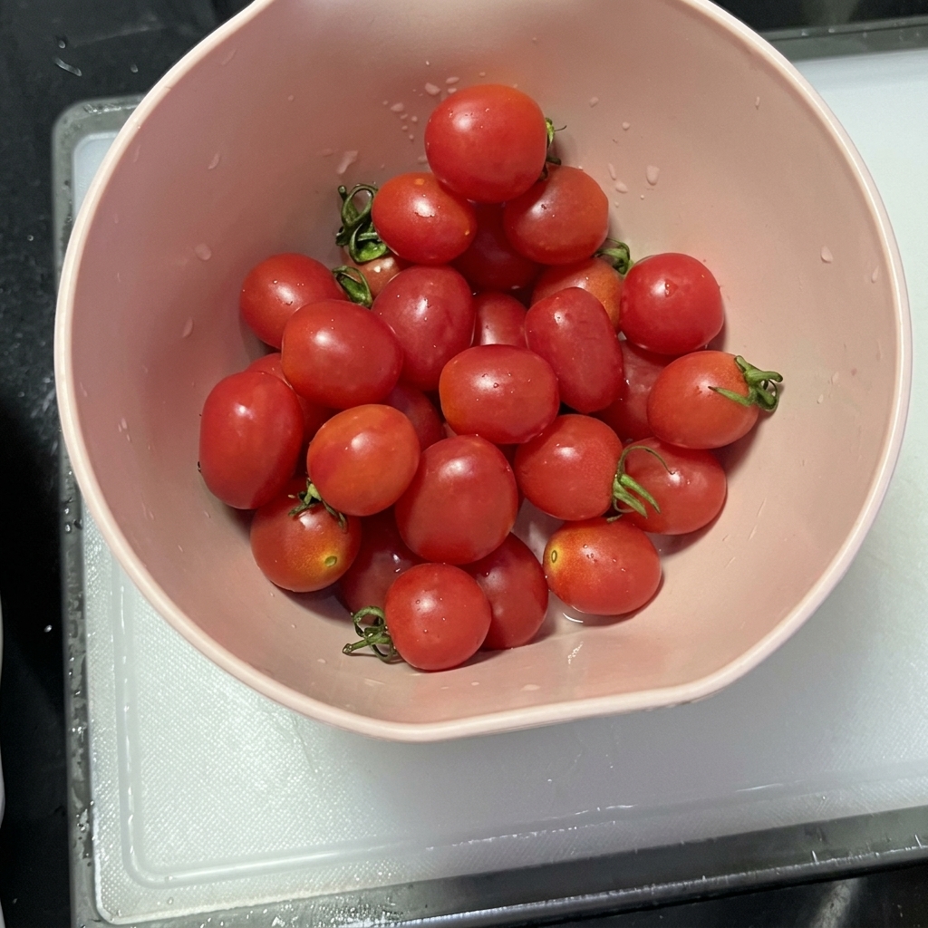 Demi-tomates cerises disposées sur une planche à découper propre après avoir été tranchées.