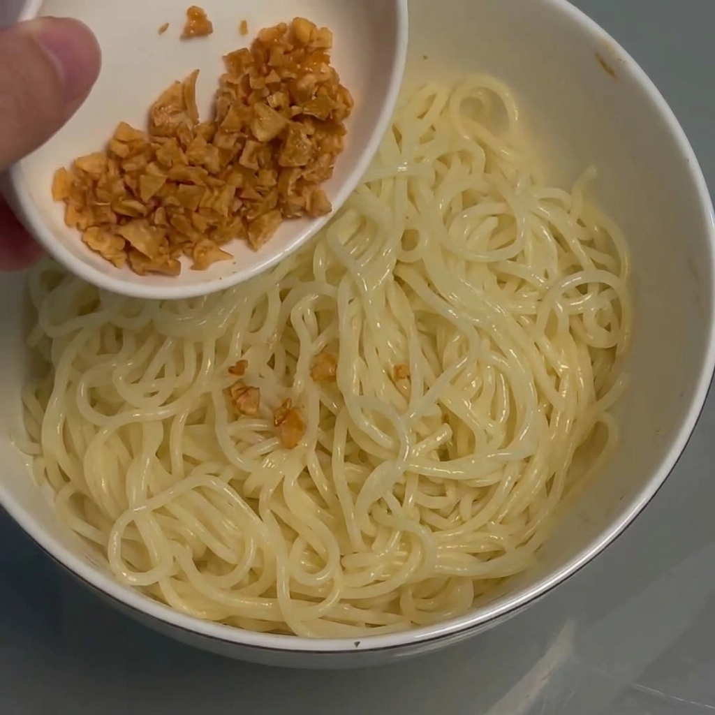 Ail frit croustillant saupoudré sur un bol de nouilles.