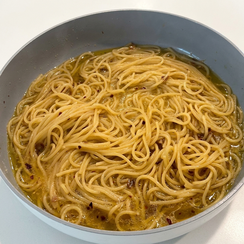 Assaisonnement des pâtes avec du poivre noir dans la poêle.