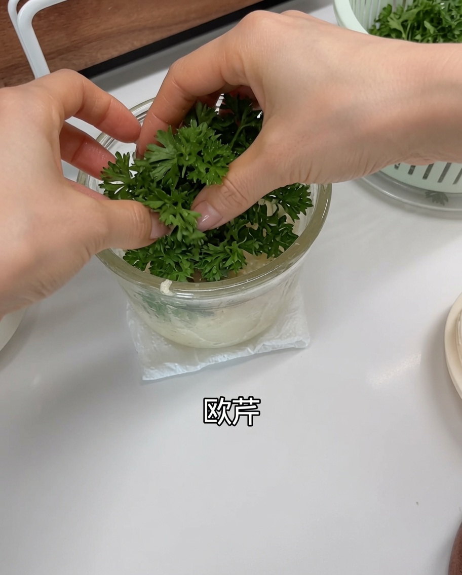 Feuilles de persil frais ajoutées dans le mixeur par-dessus lail et les échalotes.