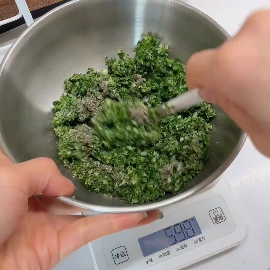 Gros plan du mélange aux herbes remué dans un bol en inox avec une spatule blanche.