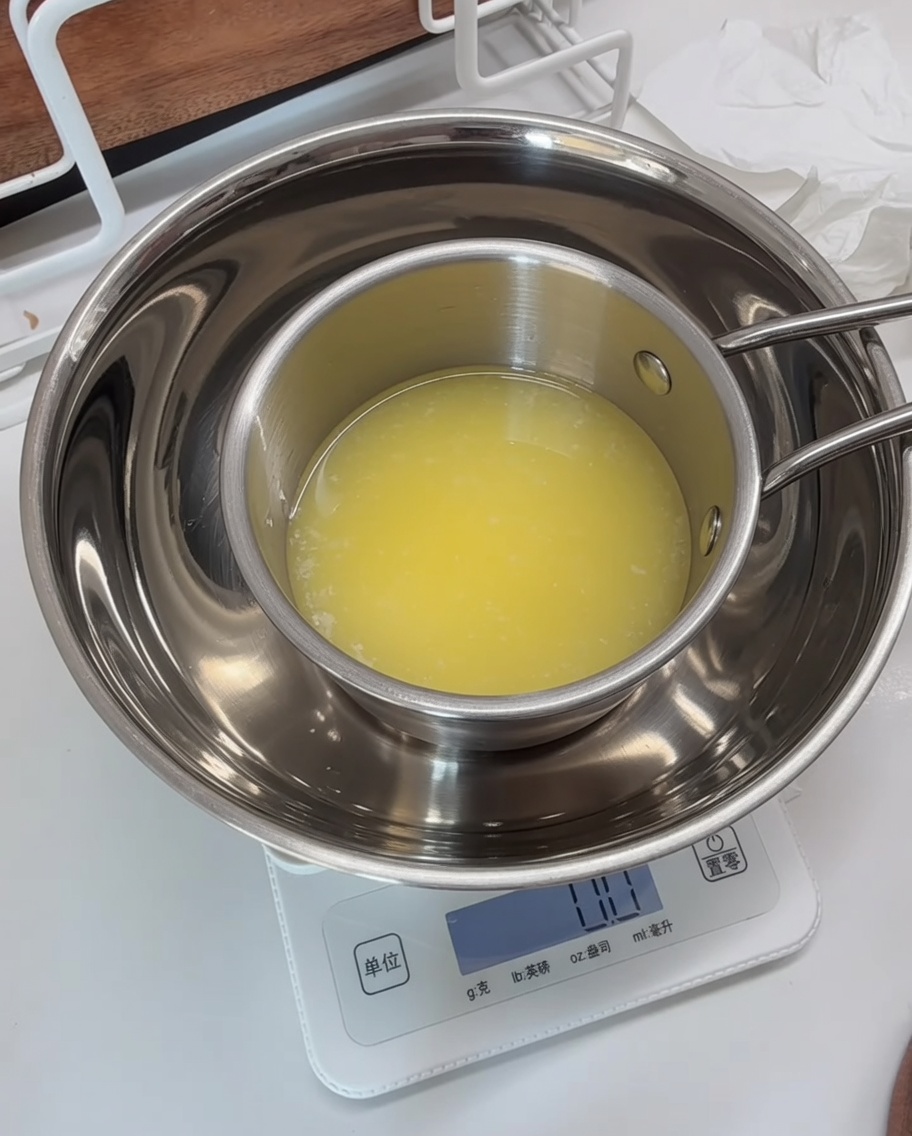 Bol sur une balance avec le mélange aux herbes combiné à du beurre fondu.