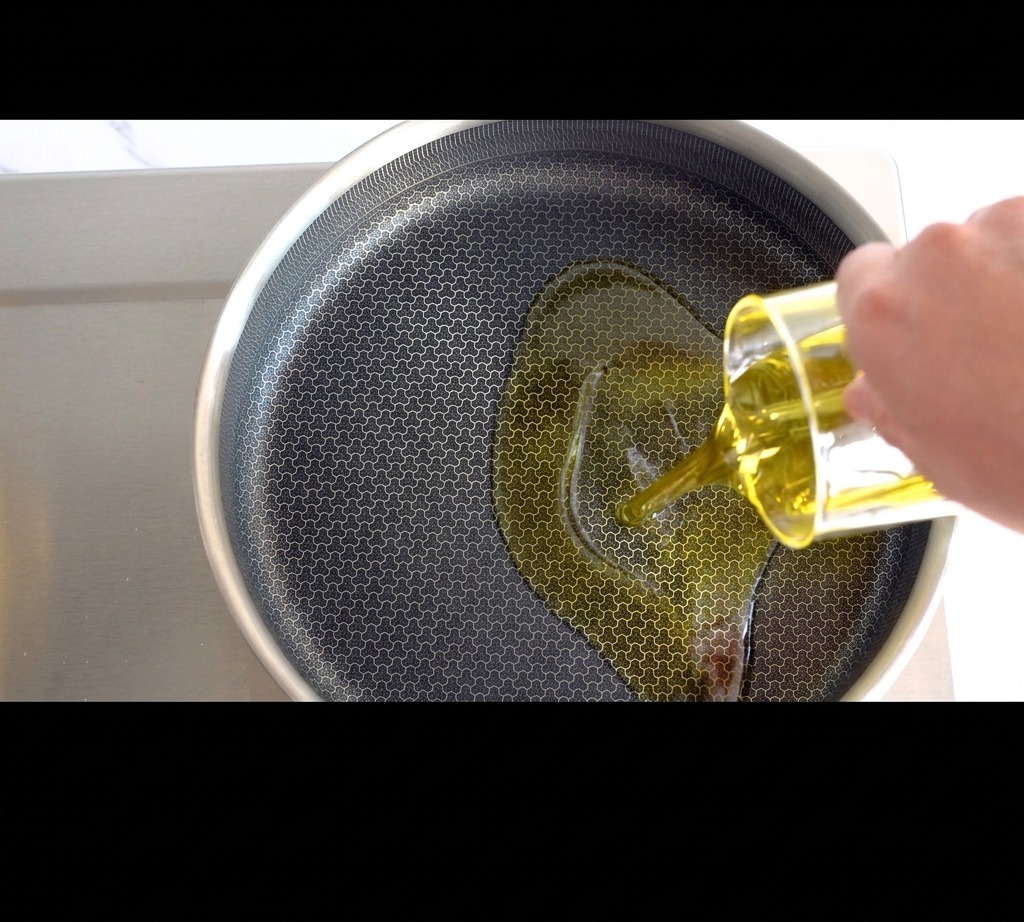 Huile dolive dorée versée dans une poêle sur la cuisinière.