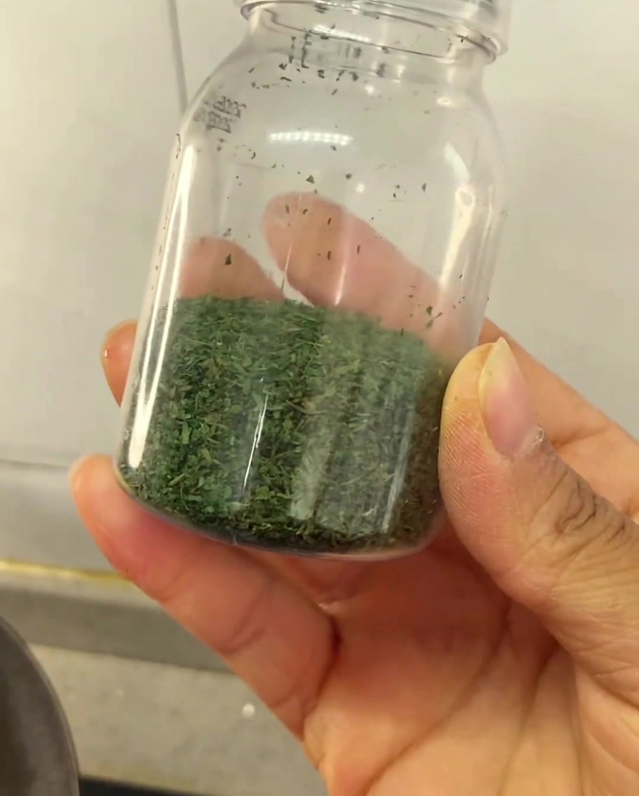 Un petit pot transparent rempli de la poudre de céleri maison.