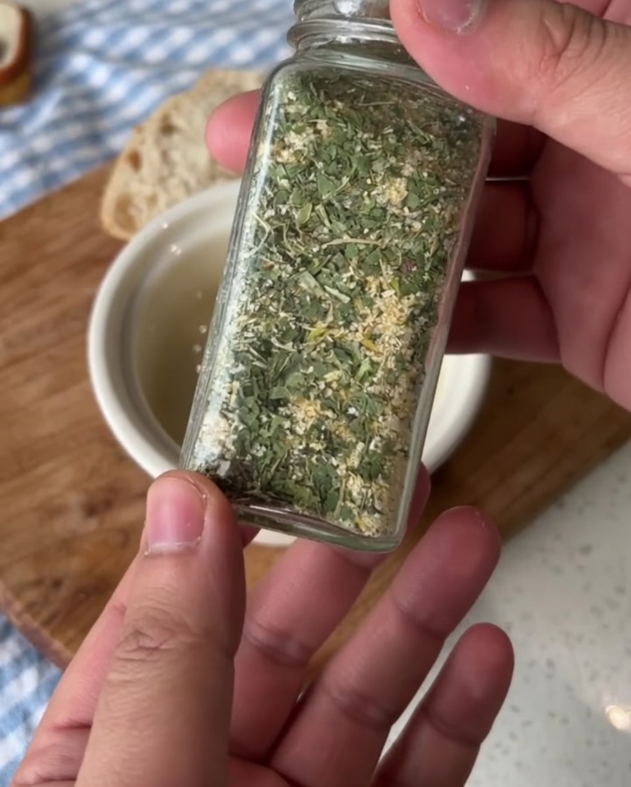 Un petit bol en céramique contenant du beurre ramolli, assaisonné de sel dail au persil.