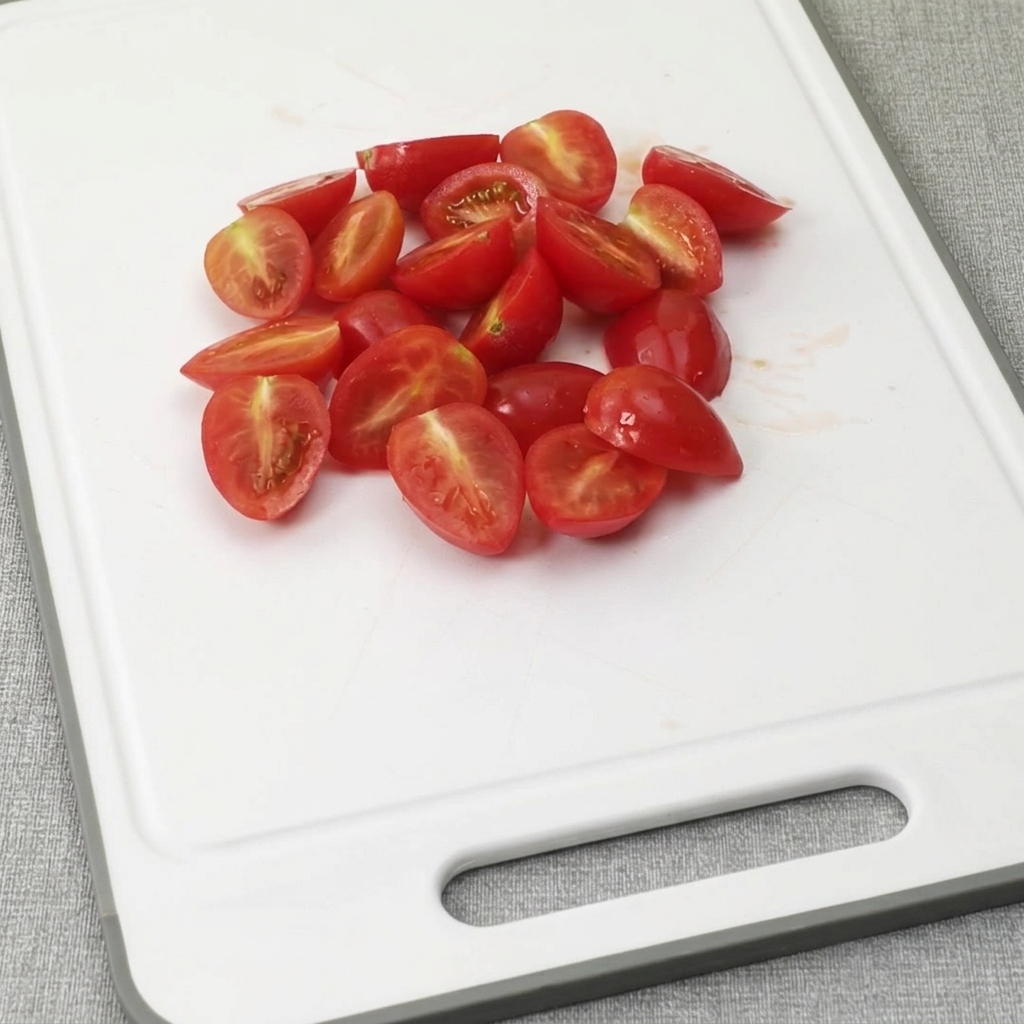 Tranches de bacon coupées en petits morceaux sur une planche à découper en plastique blanc.