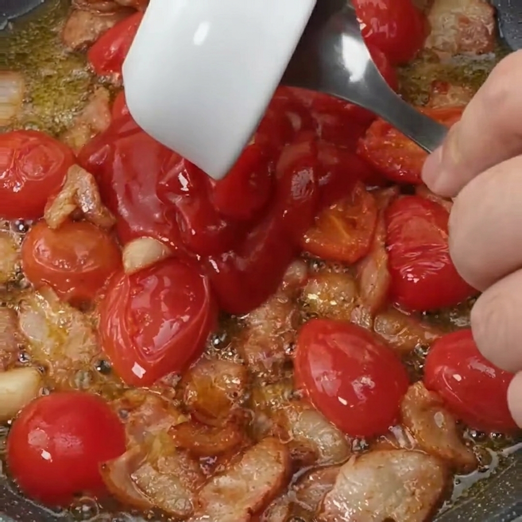 Sauce tomate et sucre ajoutés dans la poêle avec le bacon et les tomates.