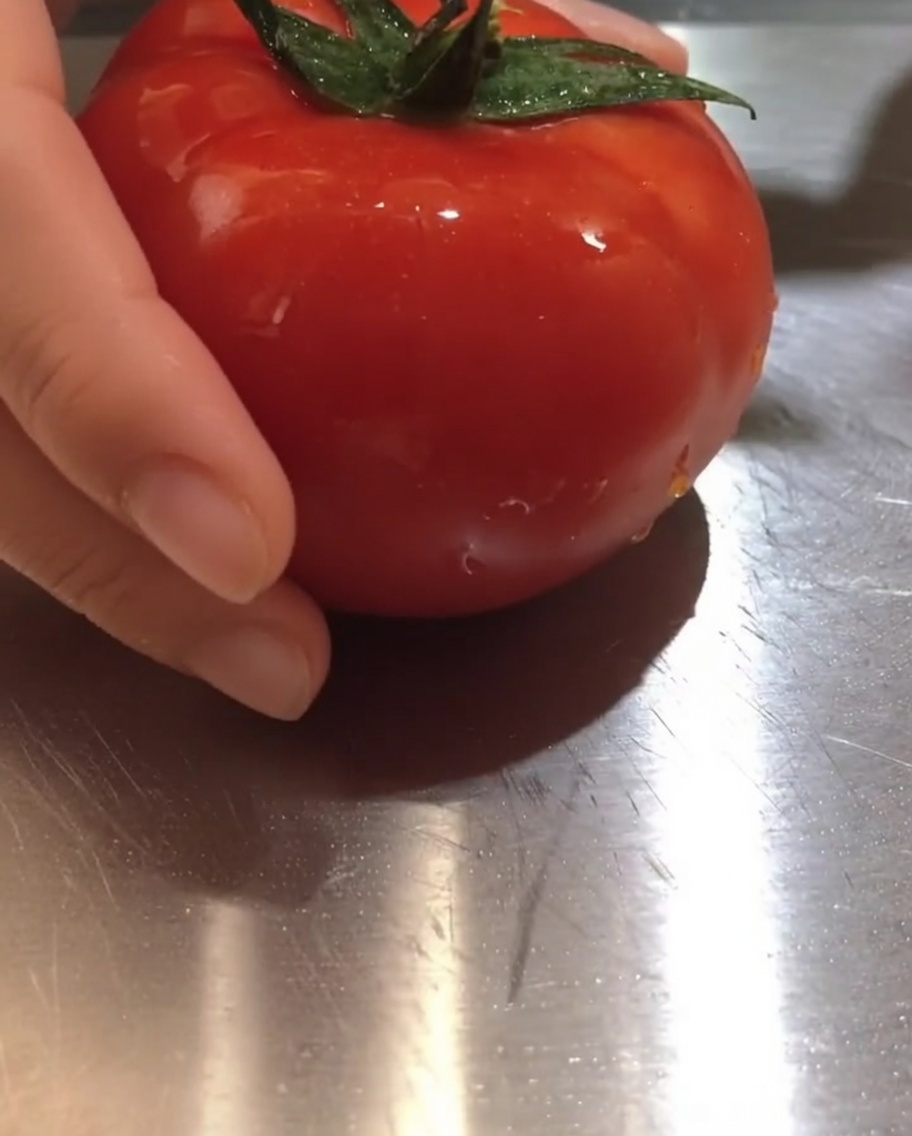 Morceaux de tomate fraîche sur une planche à découper.