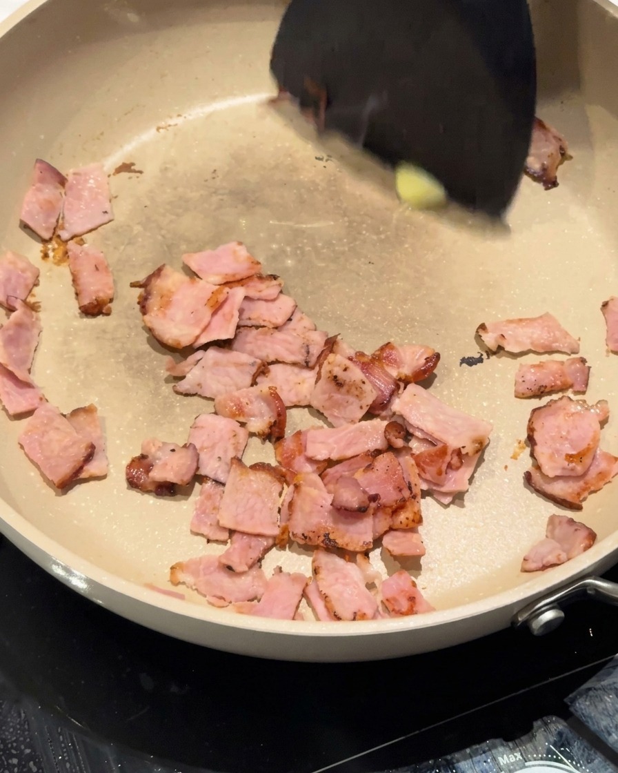 Oignons hachés en train de revenir avec le bacon et le beurre.
