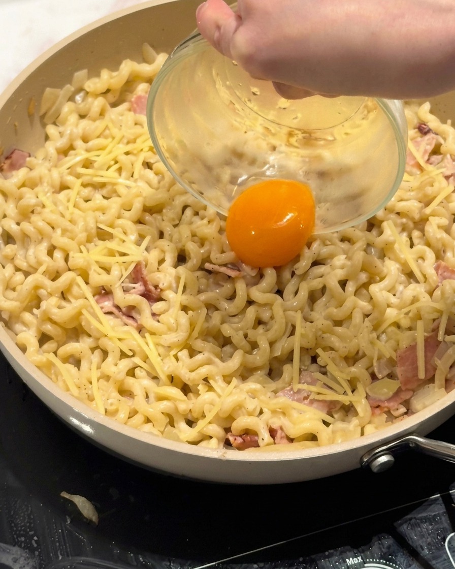 Un jaune dœuf frais placé au centre du plat de pâtes.