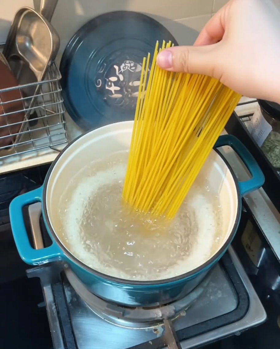 Spaghettis plongés dans une casserole deau bouillante.