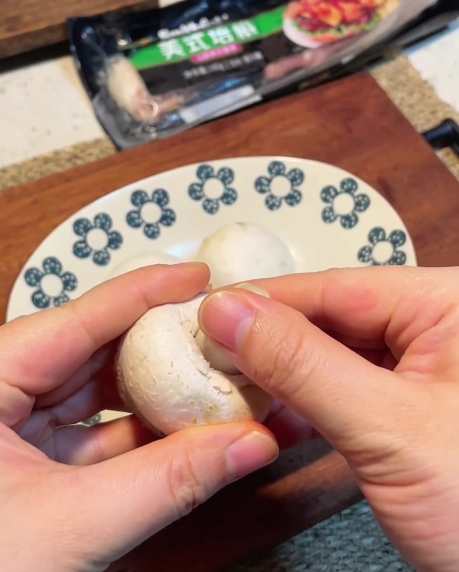 Champignons de Paris émincés sur une planche en bois.