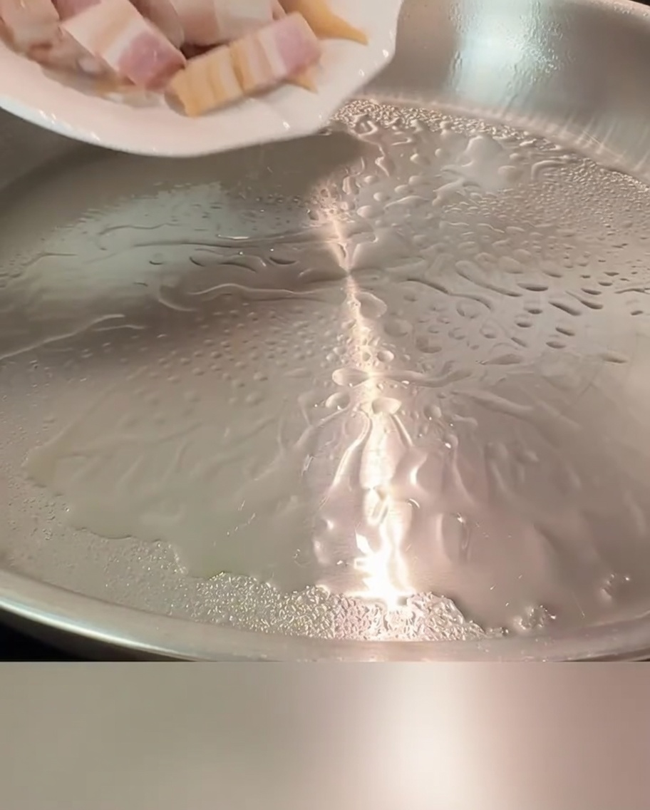 Des morceaux de lardons grésillant dans une poêle chaude jusquà devenir dorés et croustillants.