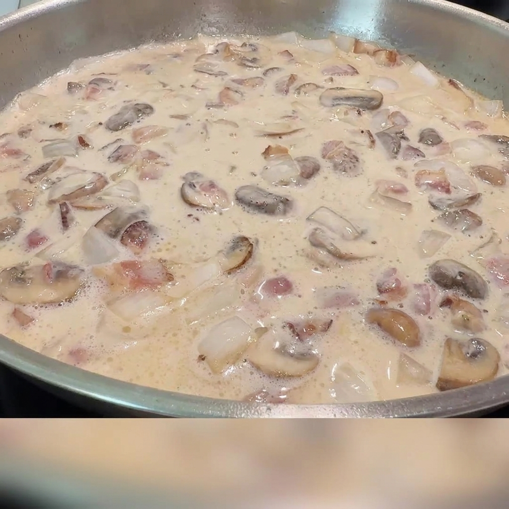 Du sel et du poivre noir saupoudrés dans la sauce crémeuse aux lardons et champignons.