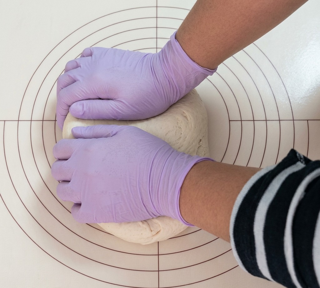 Une portion de pâte divisée avec soin en segments réguliers sur un tapis de cuisson en silicone.