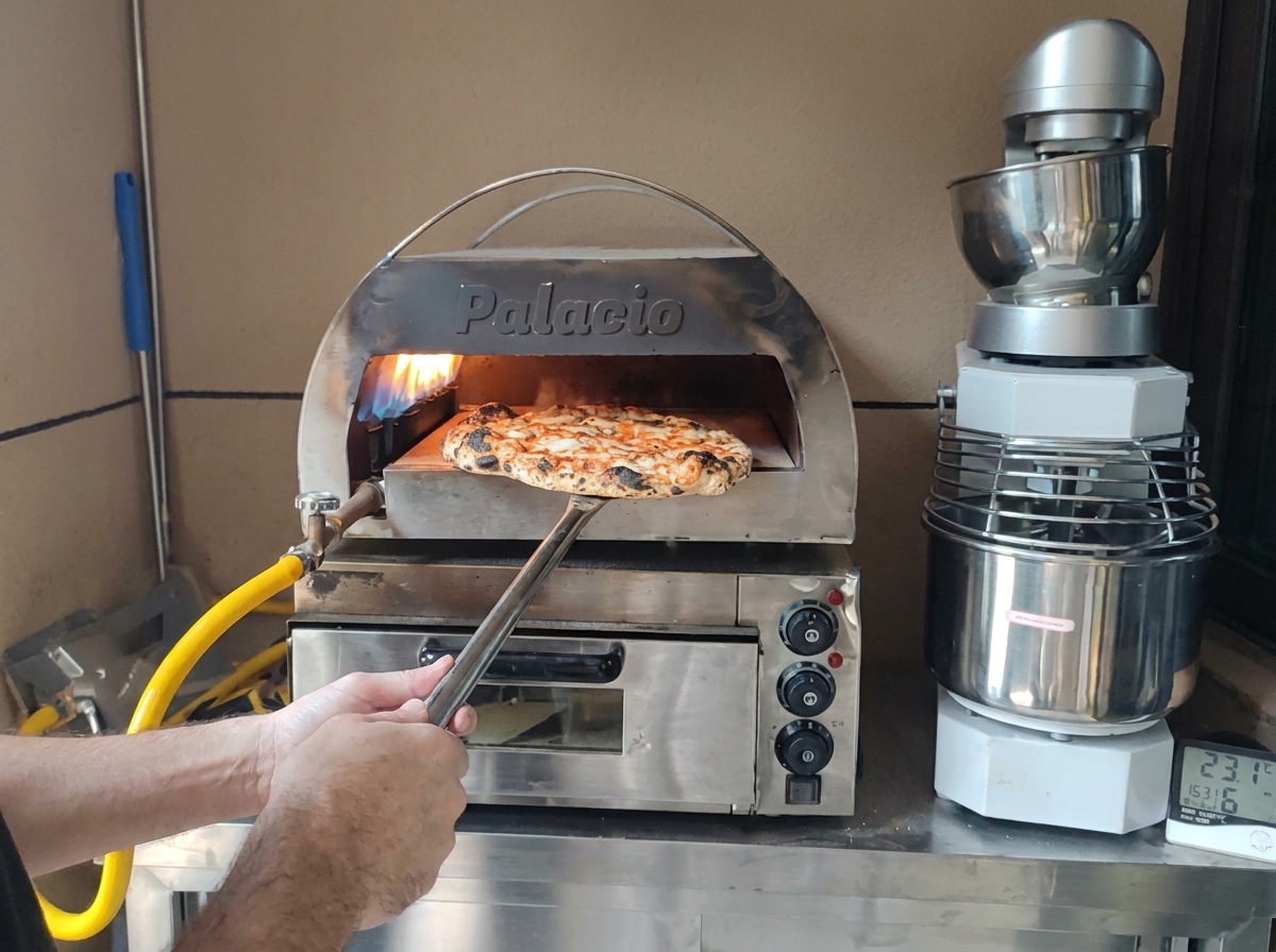 Une pizza parfaitement cuite avec une croûte dorée sortie du four sur une pelle en métal.