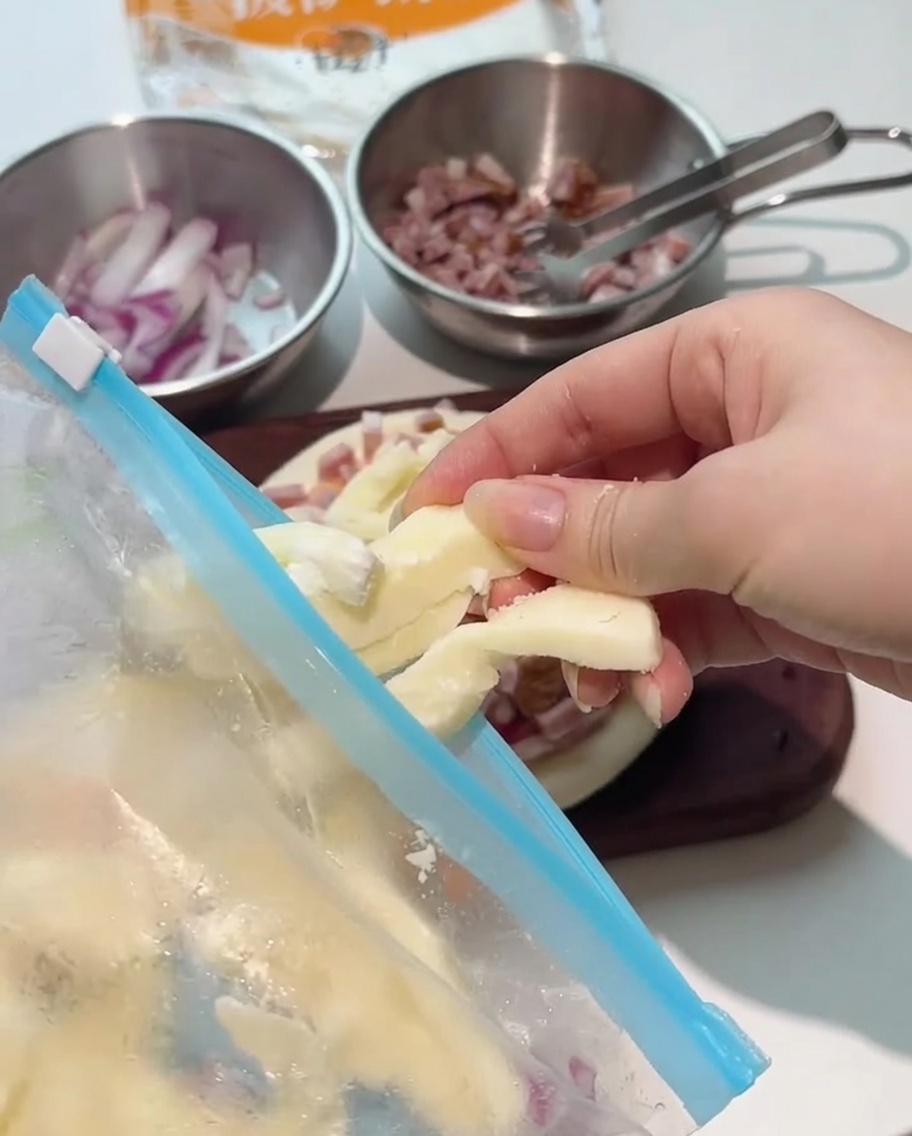 De généreuses lamelles de mozzarella déposées sur la garniture de la pizza.