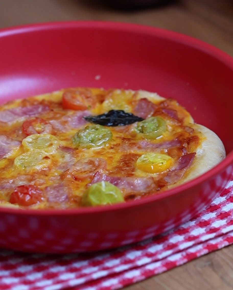 Une fourchette utilisée pour percer de petits trous sur toute la surface centrale de la pâte à pizza crue.