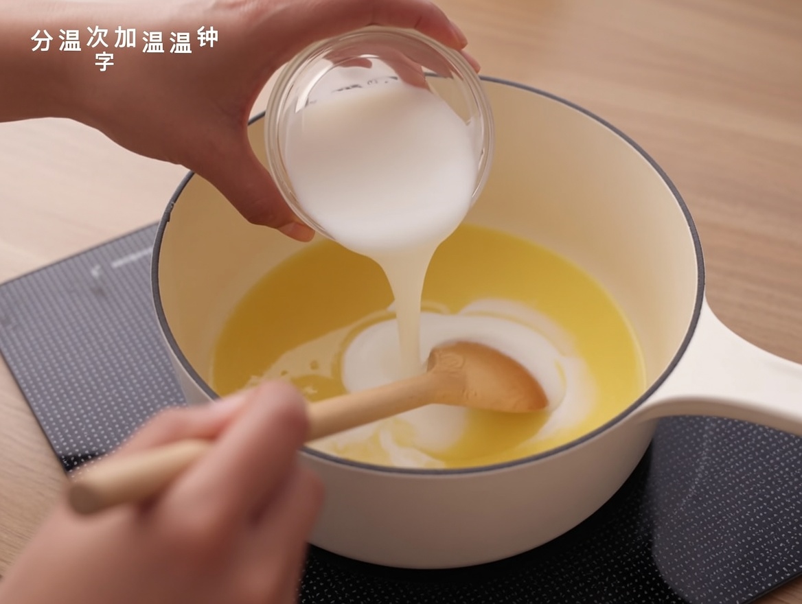 Du lait versé dans une base de roux dans une casserole, mélangé avec une cuillère en bois.