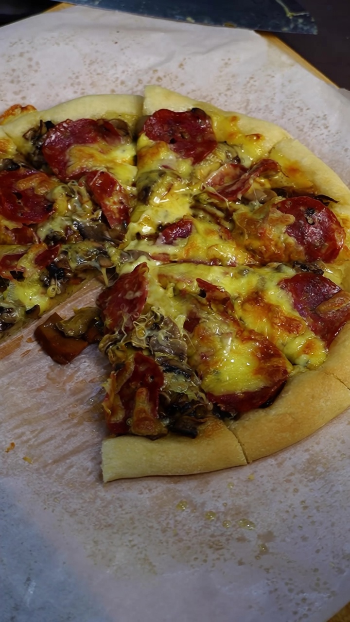 Une pizza maison tout juste sortie du four, généreusement garnie de fromage fondu, de champignons rôtis et de tranches de pepperoni.