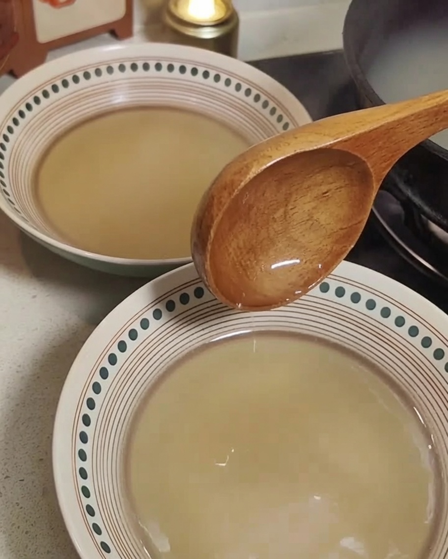 Nouilles à ramen cuites ajoutées dans des bols de bouillon préparés.