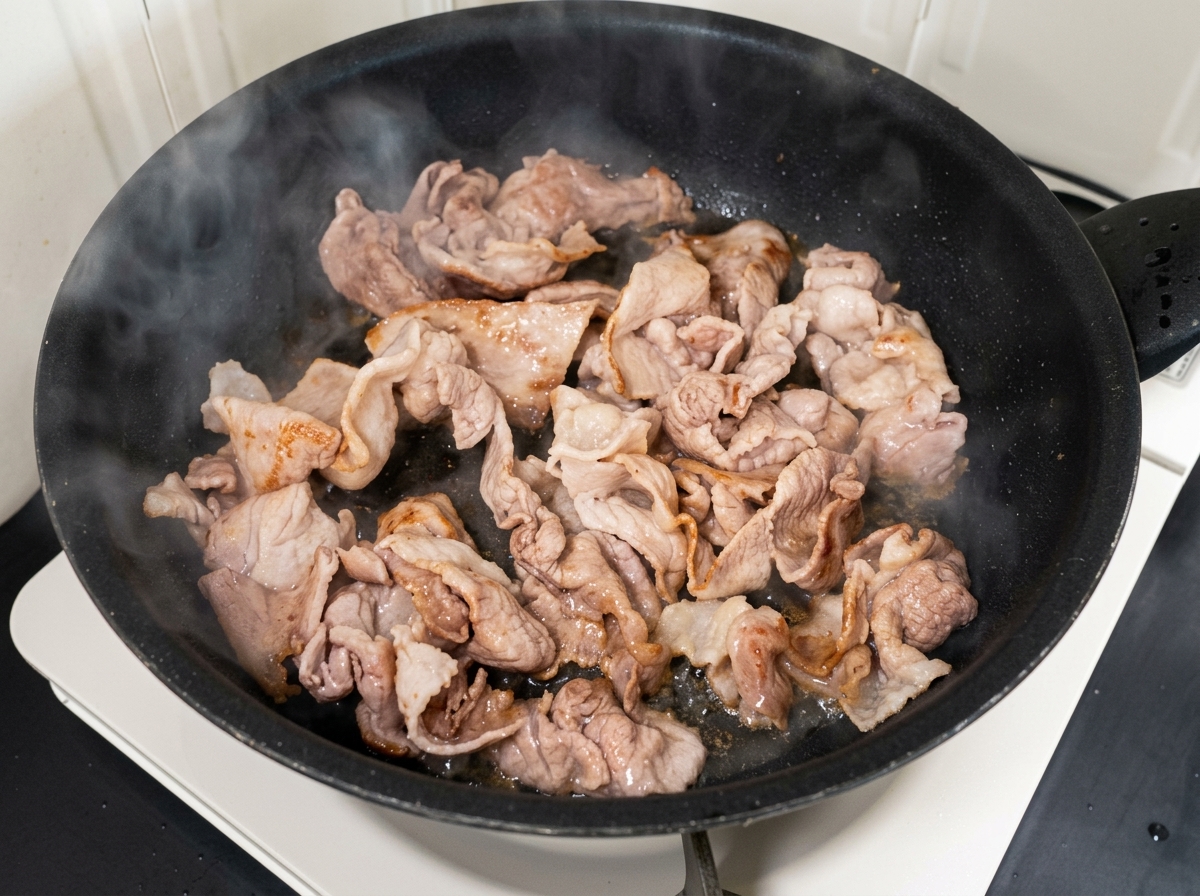 Kimchi haché et sucre mélangés avec le porc cuit dans la poêle.