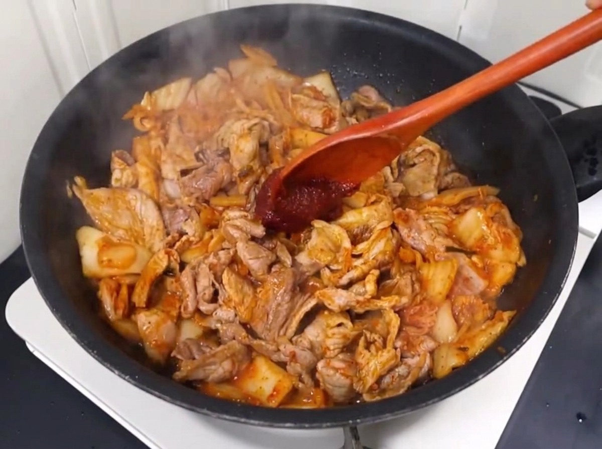 Pâte de piment et poudre de piment mélangées au porc et au kimchi.