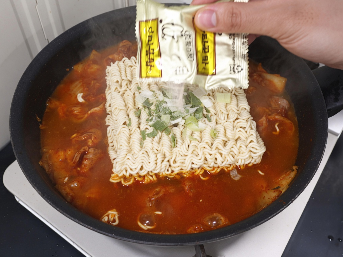 Sachet dassaisonnement versé sur les nouilles ramen et le bouillon.