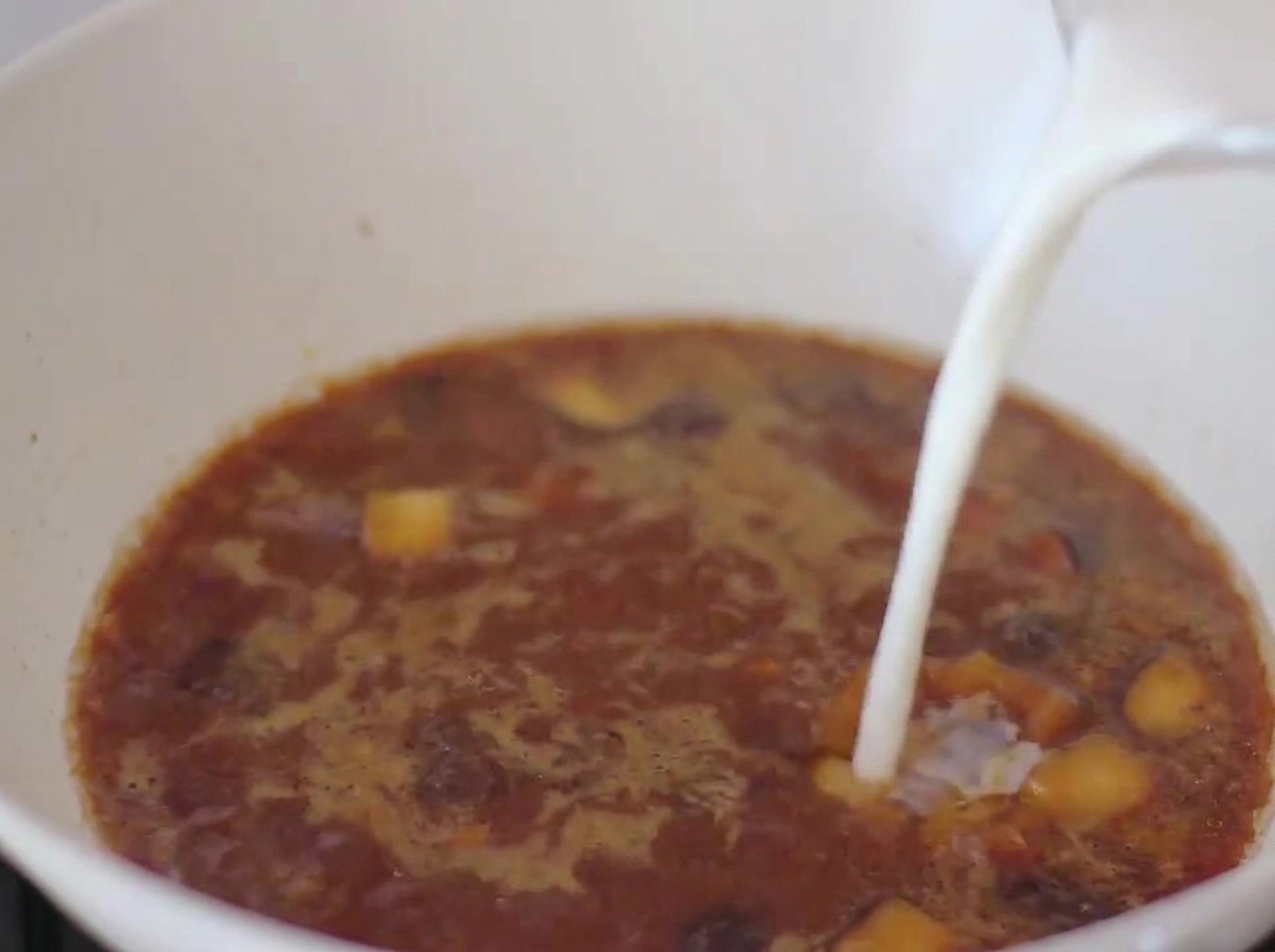 Lait versé dans le bouillon au miso dans la poêle.