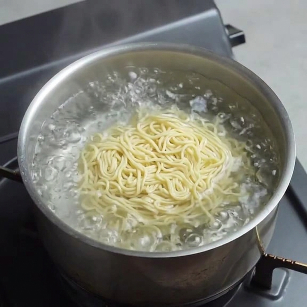 Nouilles ramen fraîches cuisant dans leau bouillante.