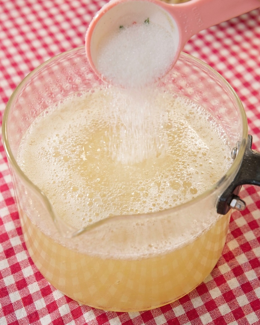 Une cuillerée de sucre blanc ajoutée au bouillon de ramen frémissant.