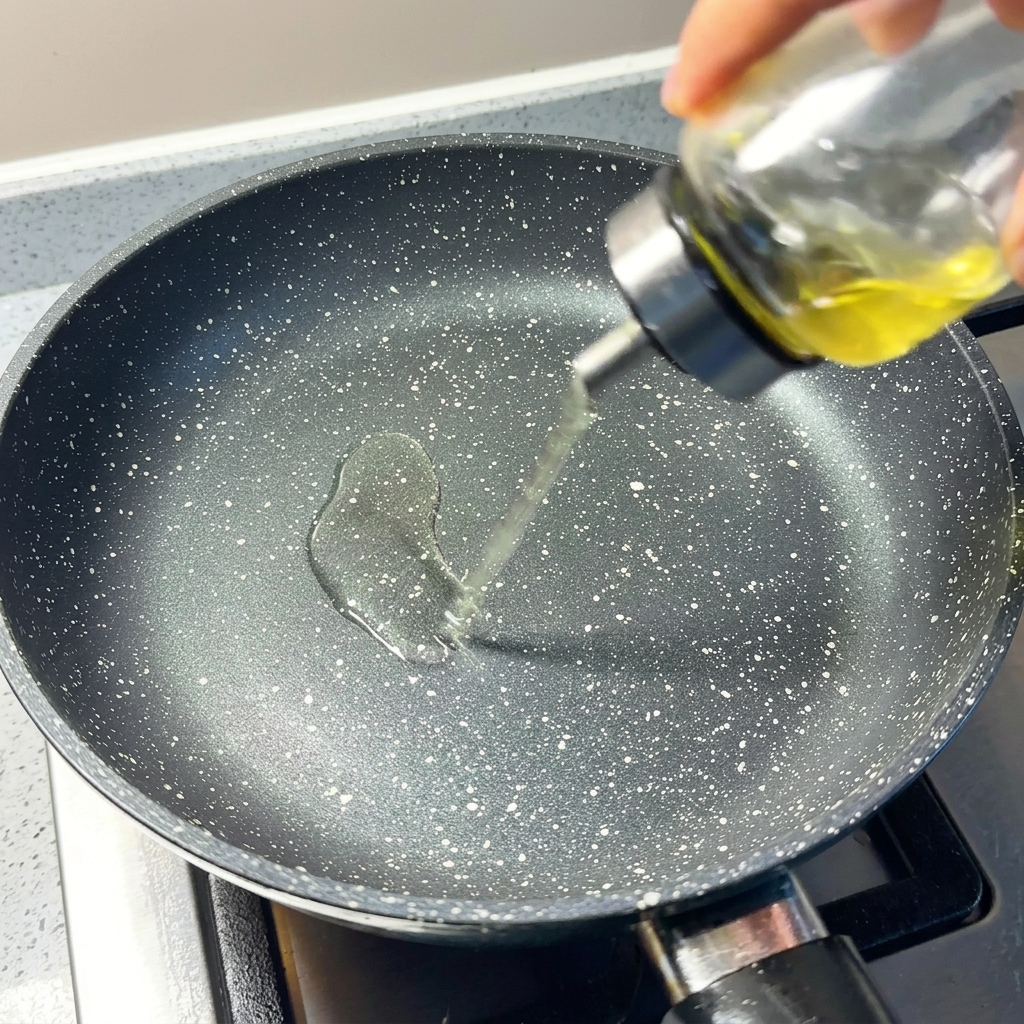 Gros plan sur de lhuile de cuisson versée dans une poêle antiadhésive préchauffée.