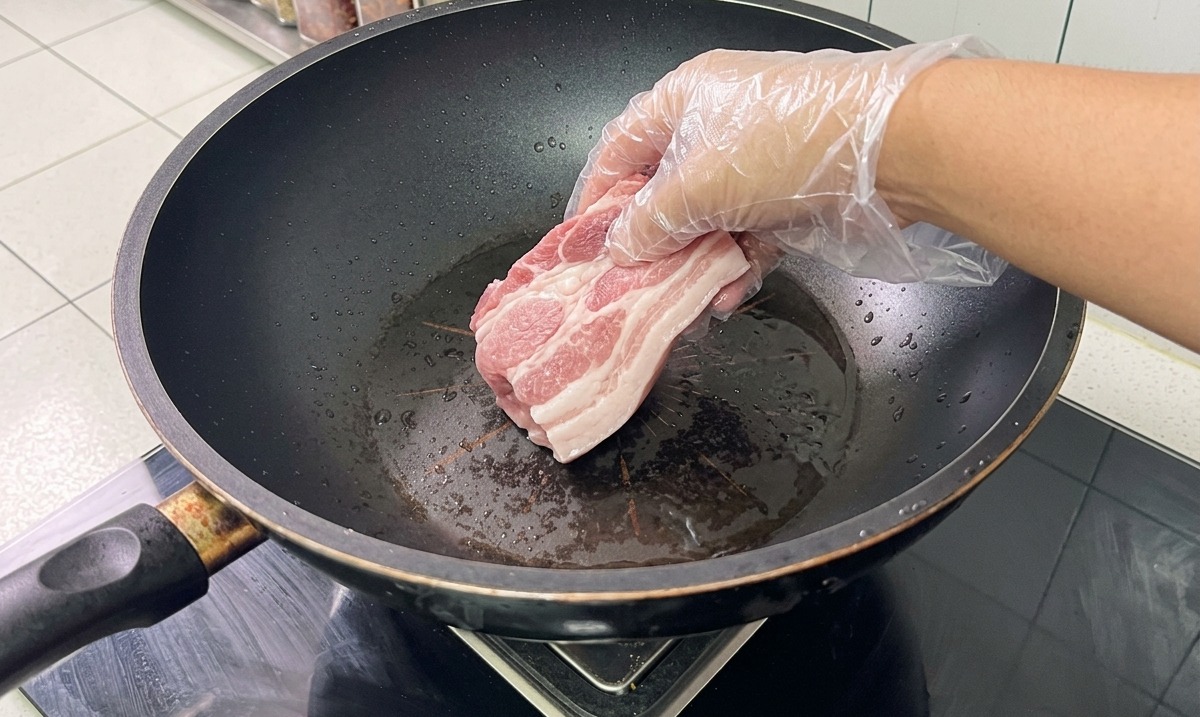 Os et poitrine de porc dans un wok deau avec des aromates en cours de blanchiment.