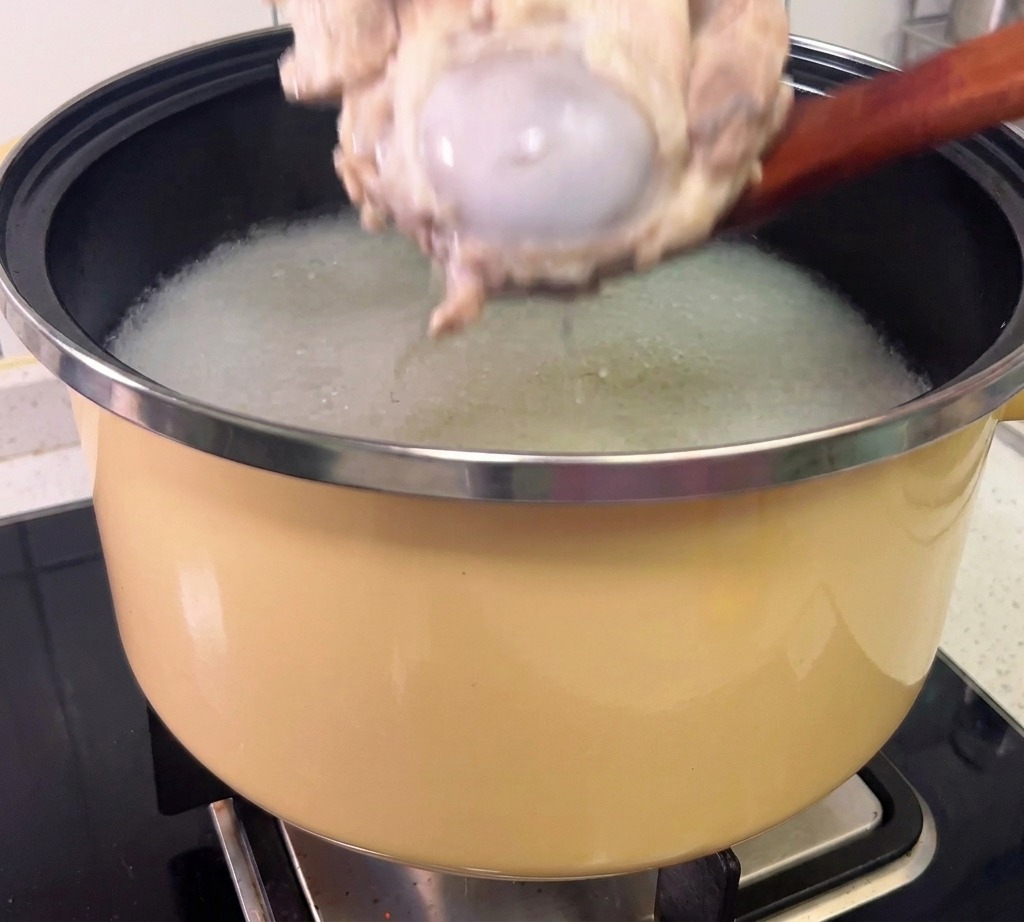 Viande détachée des os de porc cuits avec des gants de protection.