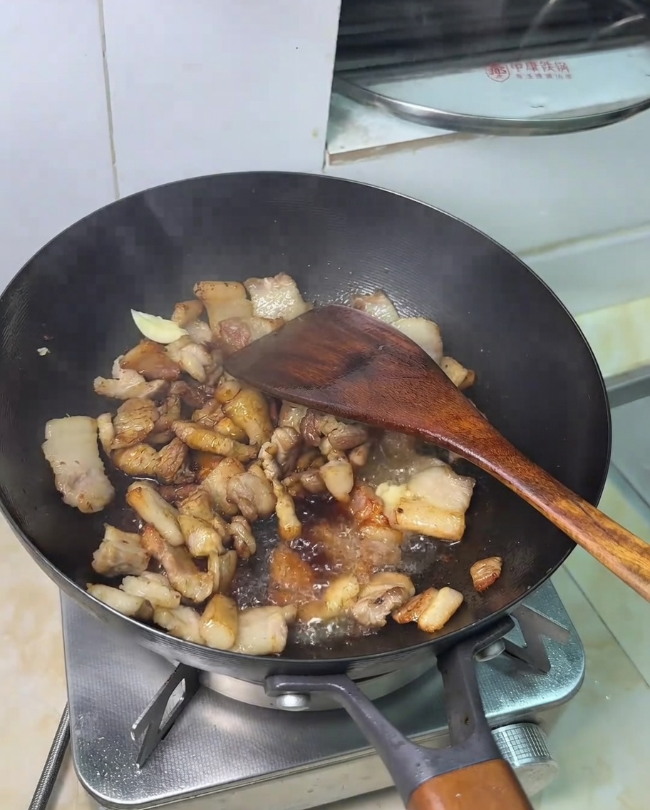 Une cuillère de sucre ajoutée au mélange de porc et de sauce soja.