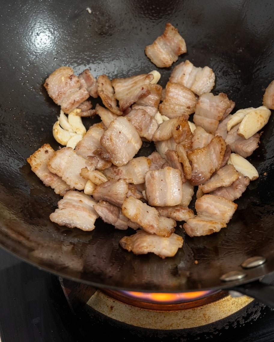 Haricots noirs fermentés ajoutés dans le wok avec le porc et lail.