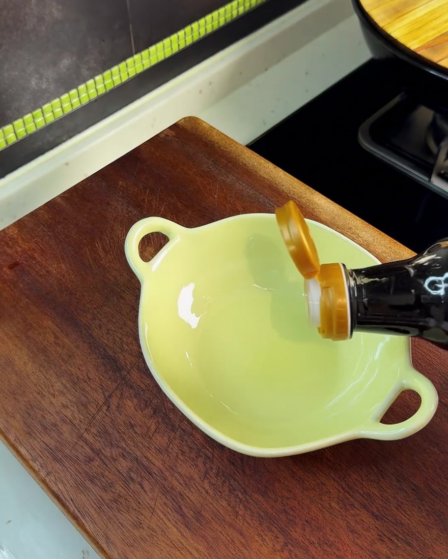 Sauce soja versée dans un petit bol jaune contenant du sel, du MSG et du sucre.