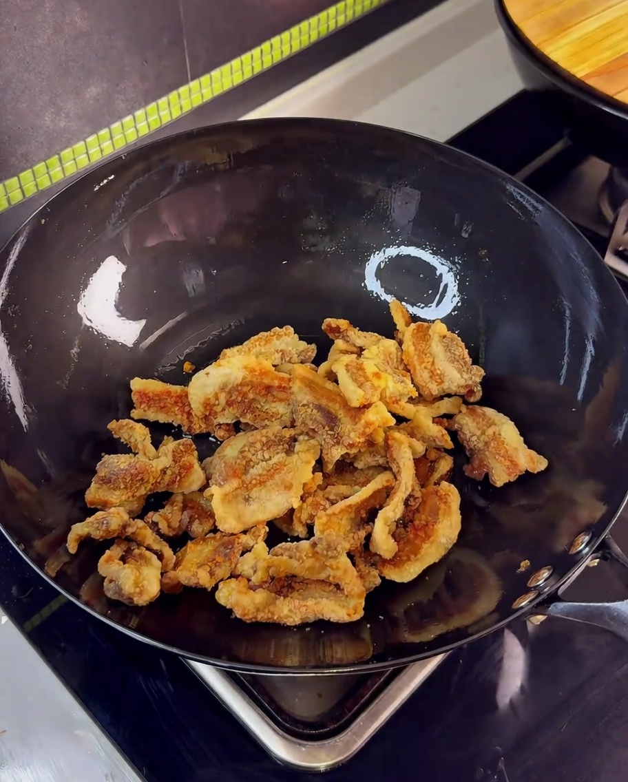 Morceaux de porc frits dans un wok sautés avec de lail et la sauce soja.