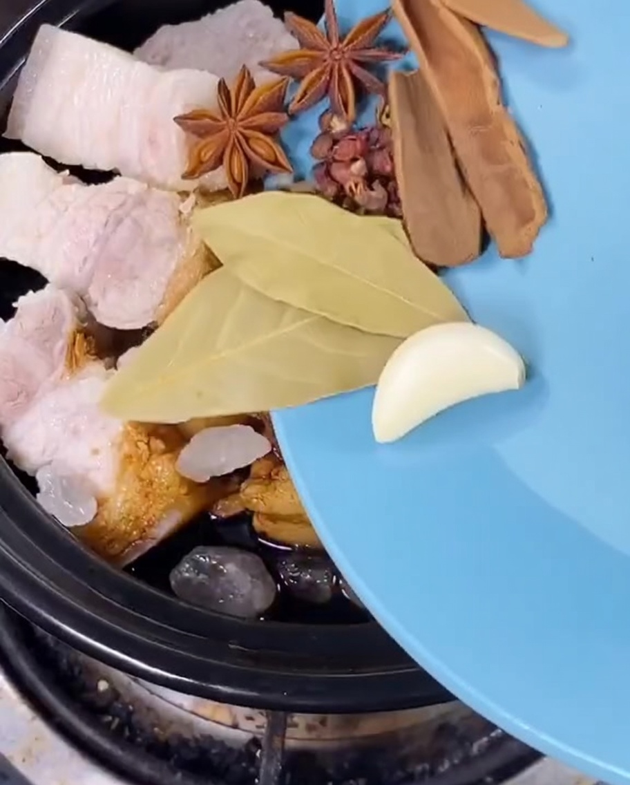 Anis étoilé, feuilles de laurier, écorce dagrume et oignons verts ajoutés à la cocotte de porc.