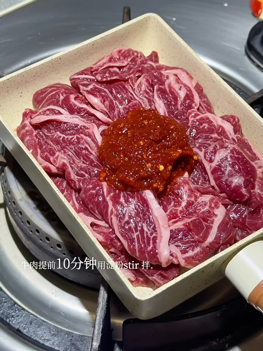 Lanières de bœuf grésillantes dans une poêle, enrobées dune sauce coréenne rouge épicée.