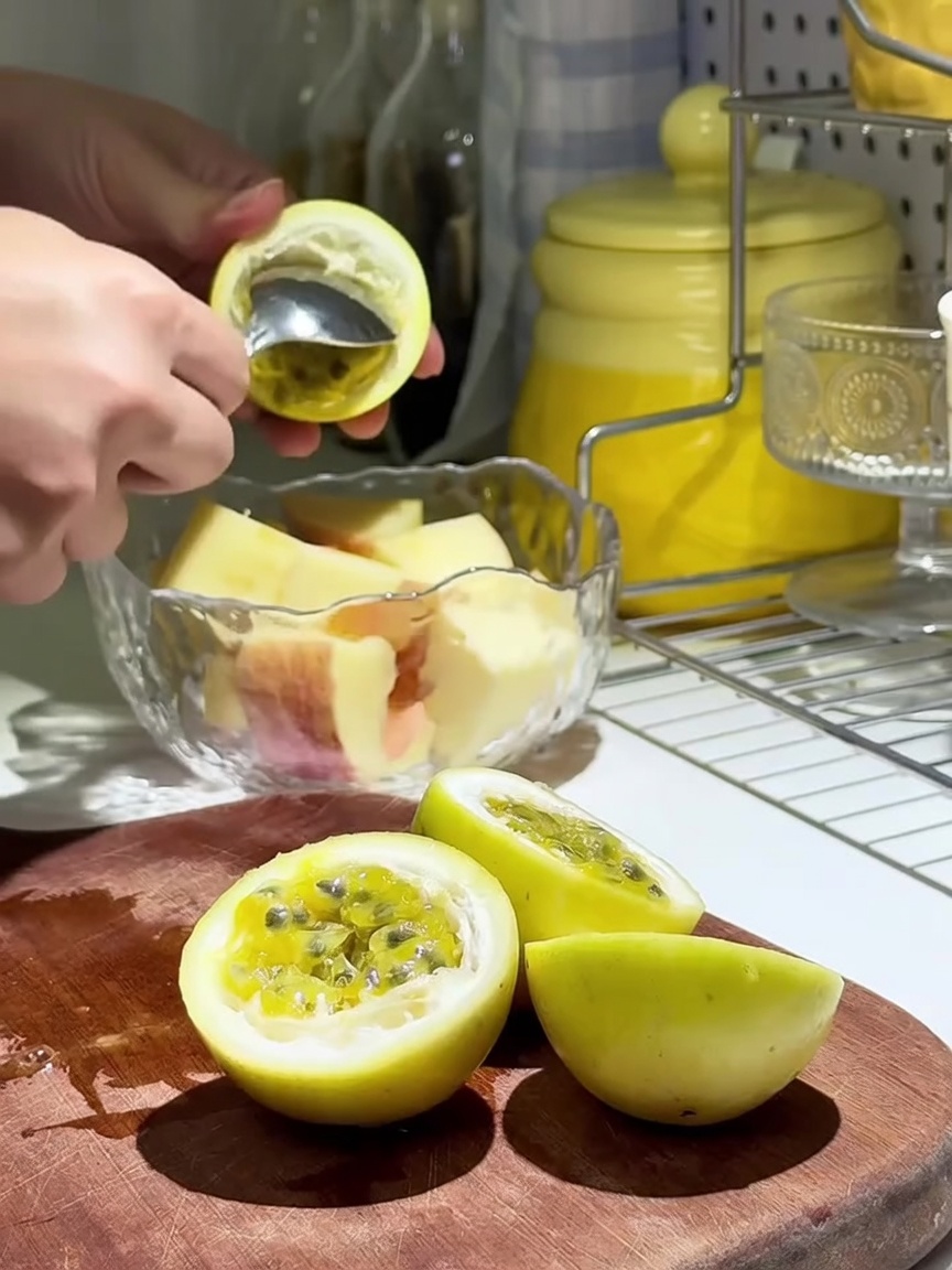 Pulpe de fruit de la passion fraîche versée sur des tranches de pomme dans un bol en verre.